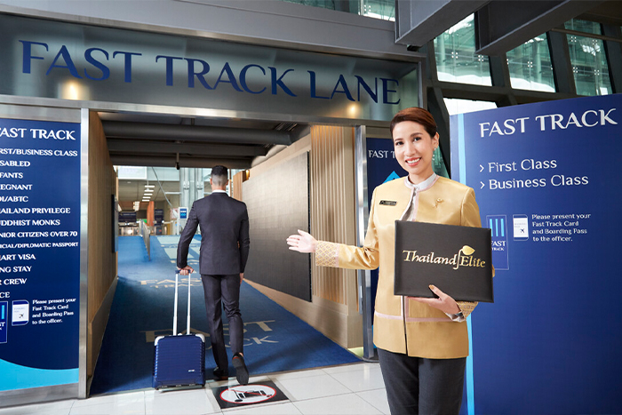 空港のファストトラック入口で利用者を案内するスタッフ